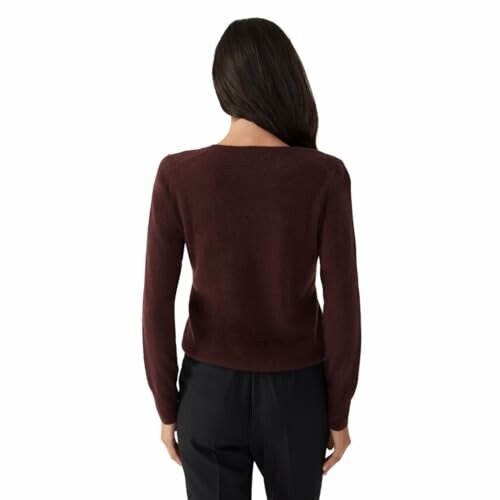 Woman in burgundy sweater with black pants, back view